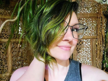 Photo of Sam our massage therapist. Her hair is green like her plants!
